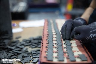 Zum Lackieren werden die Beläge von Hand auf  Matten platziert.