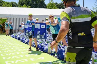 Beim Wechsel auf die Laufstrecke reichen Helferinnen den passenden Beutel mit den Laufschuhen.