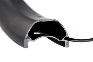 Bei H_Core kommen Einsätze aus Carbon rund ums Felgenbett zum Einsatz – diese Fäden oder Schienen sollen gegen harte Einschläge schützen und das Laufrad vor Schäden bewahren. Bei H_Core kommen Einsätze aus Carbon rund ums Felgenbett zum Einsatz – diese Fäden oder Schienen sollen gegen harte Einschläge schützen und das Laufrad vor Schäden bewahren.